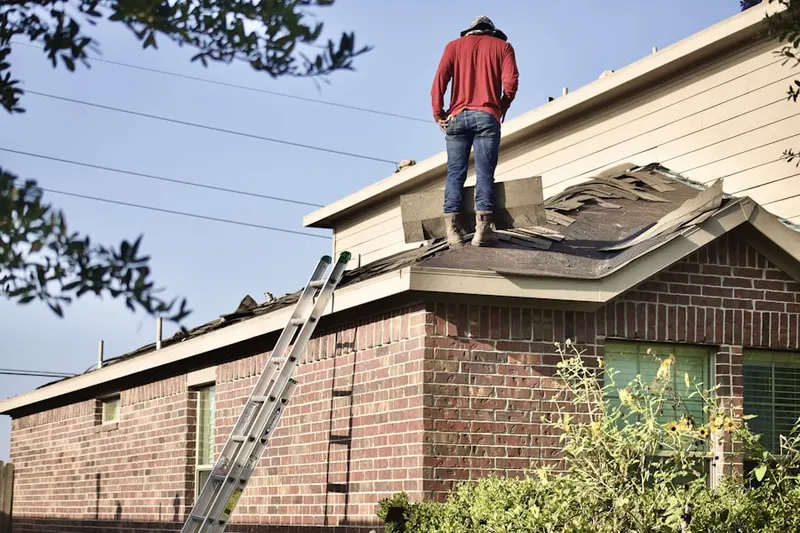 Professional roofer working on a residential roof in East Foxboro